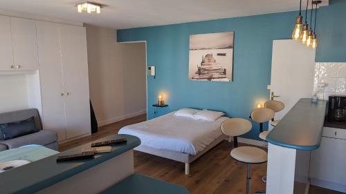 une chambre avec un lit et un mur bleu dans l'établissement Studio Vieux Port 3 étoiles, à Cannes