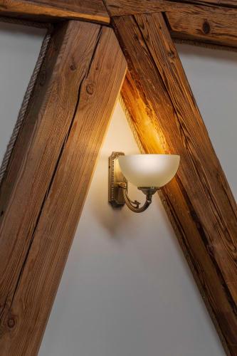 a light on a wall with a wooden ceiling at Statek 1738 in Všestudy