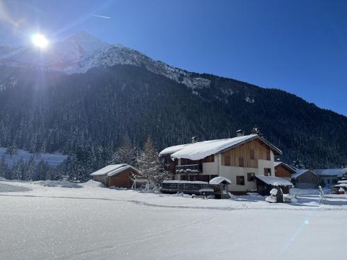 un bâtiment recouvert de neige avec une montagne en arrière-plan dans l'établissement Chalet la Grande Motte, à Champagny-en-Vanoise