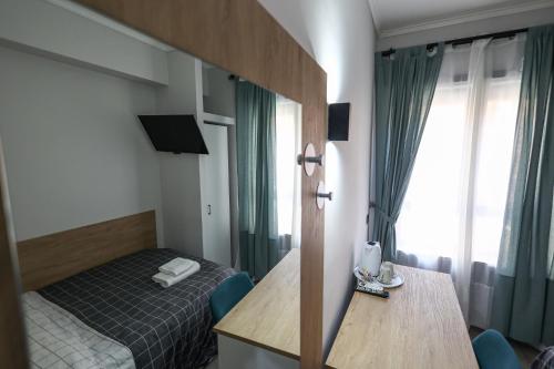 a room with a bed and a table and a window at Seven Kings Relais in Rome