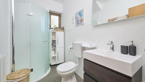 Baño blanco con aseo y lavamanos en Apartment Igor en Novigrad Istria