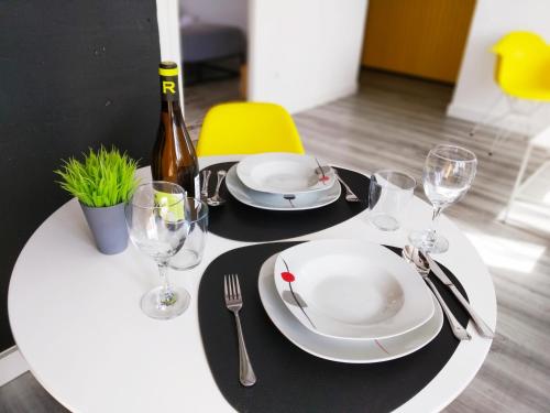 a white table with plates and wine glasses on it at XOXO - Salinas in Ponferrada