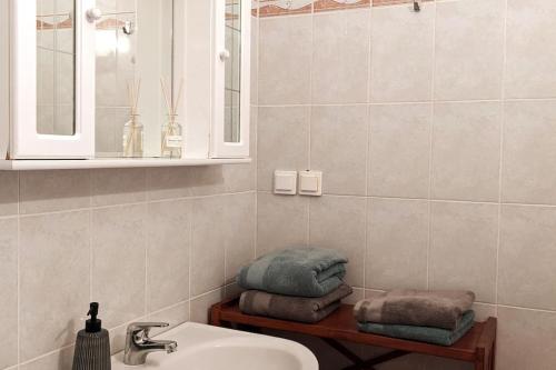 a bathroom with a sink and towels on a shelf at Haus Granes -Ferienwohnung am Meer für 2 Personen in Finikounta