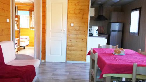 een keuken en eetkamer met een rode tafel en stoelen bij Chalets du Lac in Arcizans-Avant