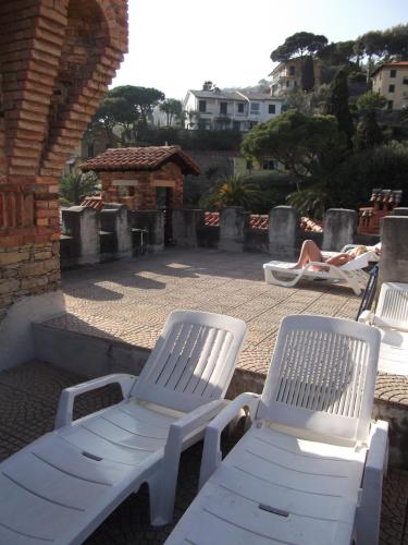 two white lawn chairs sitting on a patio at Hotel La Vela-Castello Il Rifugio in Santa Margherita Ligure