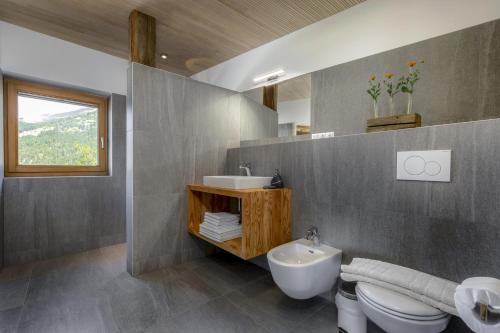 a bathroom with a sink and a toilet and a mirror at Vernalhof Apt Panorama in Sluderno