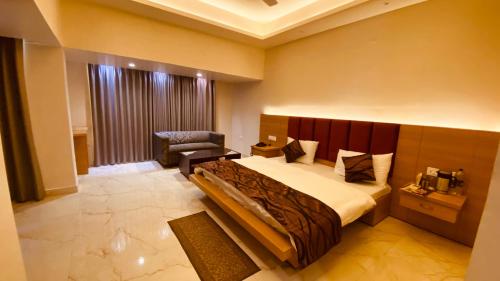 Hotel Amar Palace في امبالا: غرفة نوم بسرير كبير وكرسي