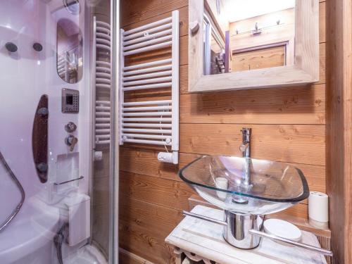 La salle de bains est pourvue d'un lavabo en verre et d'un miroir. dans l'établissement Charmant studio à Val-d'Isère avec balcon sud, proche centre, casiers à ski - FR-1-694-126, à Val dʼIsère