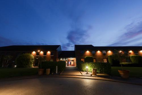 una casa con luces al costado de ella por la noche en The Waterside Hotel and Leisure Club, en Mánchester