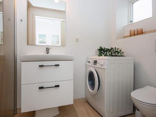 uma casa de banho branca com uma máquina de lavar roupa e um lavatório em Holiday home Ebeltoft CCXVII em Ebeltoft