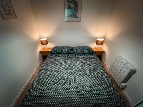 1 cama en una habitación con 2 lámparas en 2 mesas en Au cœur de Castres, logement cosy classé 3*** en Castres