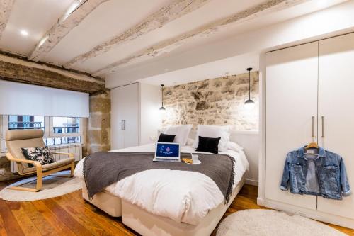 1 dormitorio con 1 cama con ordenador portátil en AMELIA suite apartment en San Sebastián