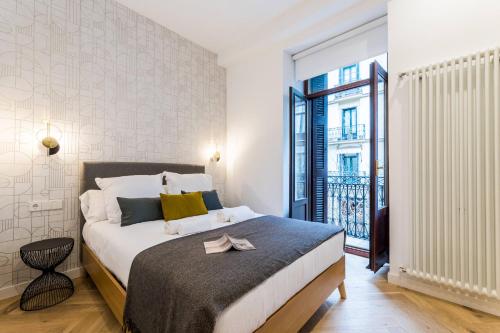 a bedroom with a large bed and a large window at CHURRUCA suite apartment in San Sebastián