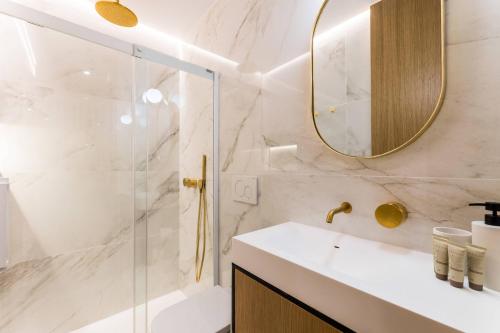 een badkamer met een douche, een wastafel en een spiegel bij CHURRUCA suite apartment in San Sebastian