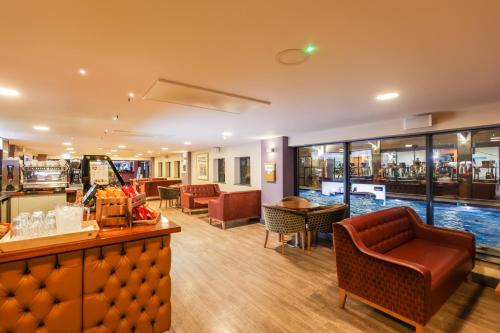 a bar with chairs and a pool in a restaurant at The Waterside Hotel and Leisure Club in Manchester