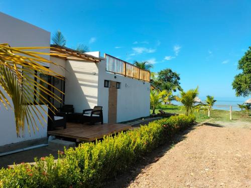 une maison sur la plage avec une terrasse en bois dans l'établissement Casa Suite Palmar del viento FRENTE, FRENTE AL MAR, à Moñitos
