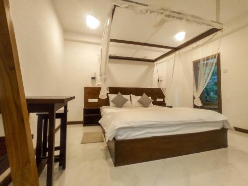 a bedroom with a bed and a desk in it at Once in Ella in Ella