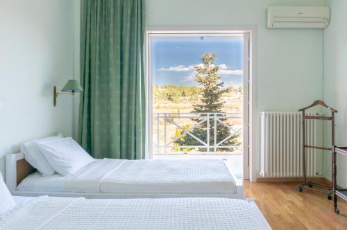 una camera con due letti e una grande finestra di Eden Garden 3BR villa with Pool by JJ Hospitality a Oropos