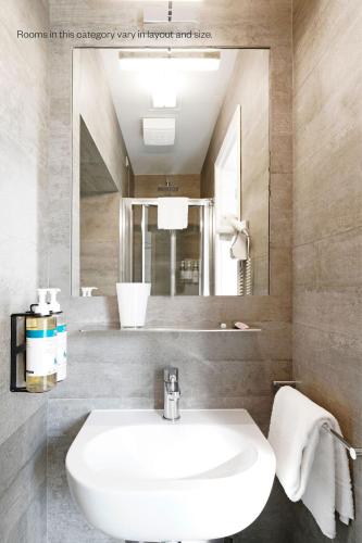 a bathroom with a white sink and a mirror at Numa Florence Rodo in Florence