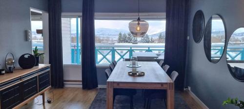 a dining room with a table and a balcony at Lund - Exellent Apartment in Tromsø