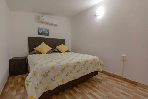 1 dormitorio con 1 cama grande con almohadas amarillas en Doña Nelly, en Asunción