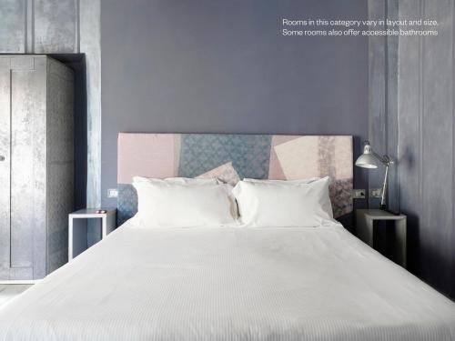 a bedroom with a large white bed with white pillows at Numa Florence Rodo in Florence