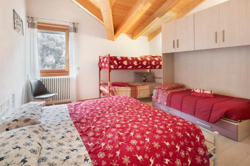 - une chambre avec 2 lits et un couvre-lit rouge dans l'établissement Casa Sergio, à Grosio