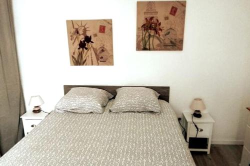 a bedroom with a bed with two pictures on the wall at T2 idéal étudiant + pro + parking protégé sous-sol in Thouaré-sur-Loire