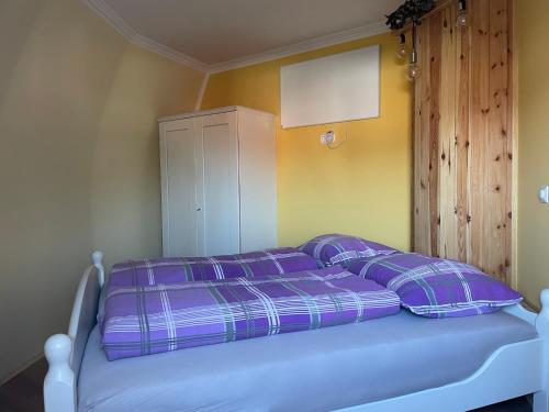 ein Bett mit lila Kissen in einem Zimmer in der Unterkunft Dirndlhaus in Kirchberg an der Pielach