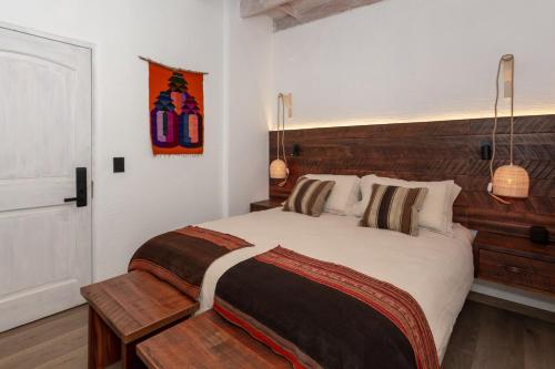 1 dormitorio con 1 cama grande y cabecero de madera en Casa Solcor Boutique Bed & Breakfast en San Pedro de Atacama