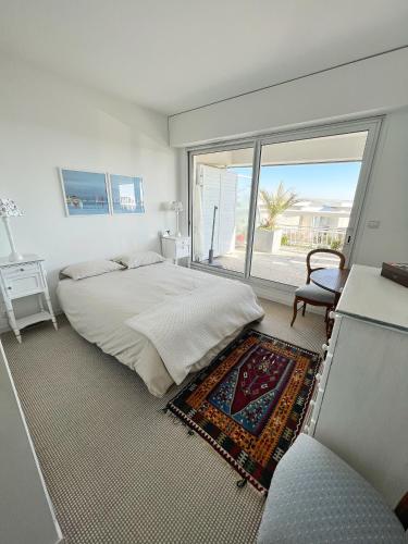 une chambre avec un lit et une grande fenêtre dans l'établissement L'Océane - Magnifique vue mer, à La Rochelle