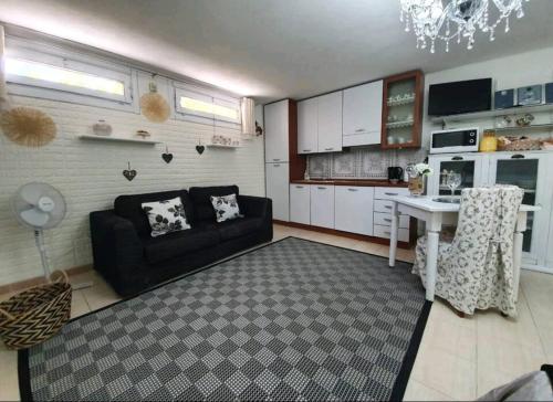 ein Wohnzimmer mit einem schwarzen Sofa und einem Tisch in der Unterkunft Holiday Home Casa Vacanza Il Gelsomino IUNQ9330 in Siniscola