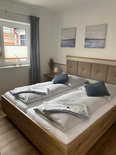 two beds in a bedroom with two windows at Kleine Hafenperle Büsum in Büsum