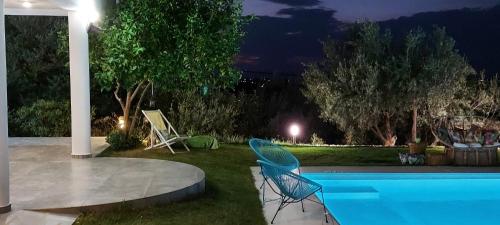 un patio trasero con piscina por la noche en HEAVENLY VIEWS-2- Elegant Ground floor Apartment with pool Close to the Beach!!, en Oropo
