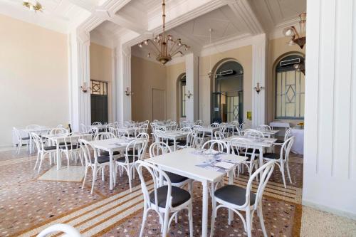 a dining room with white tables and chairs at Albergo Palazzo in Santa Cesarea Terme