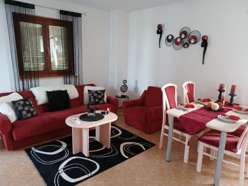 een woonkamer met een rode bank en een tafel en stoelen bij Lovely Apartment Piantade in Poreč
