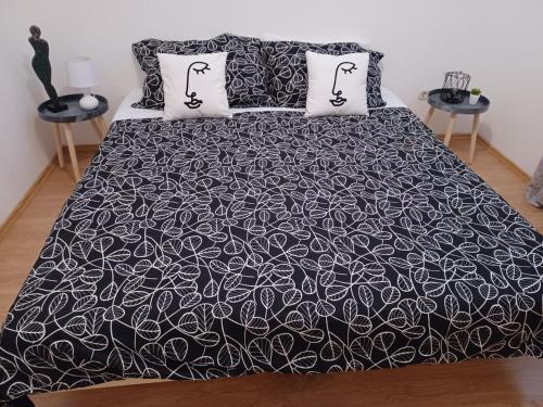 een bed met een zwart-witte deken en kussens bij Lovely Apartment Piantade in Poreč