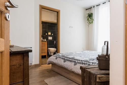 um quarto com uma cama e uma casa de banho com um lavatório em Charming one-of-a-kind apartment. em Saint-Ouen