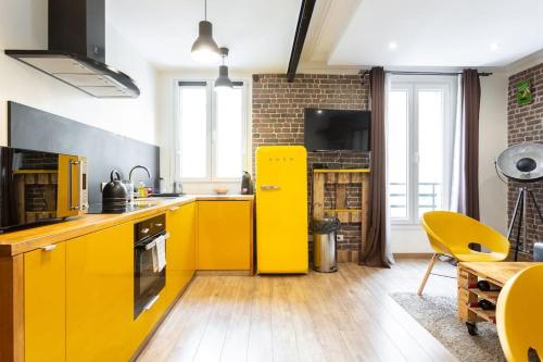 une cuisine avec des armoires jaunes et un réfrigérateur jaune dans l'établissement Charming one-of-a-kind apartment., à Saint-Ouen