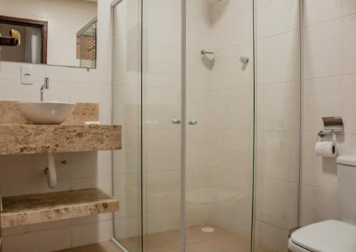 a bathroom with a glass shower stall and a toilet at Pousada Chayenne in Piranhas