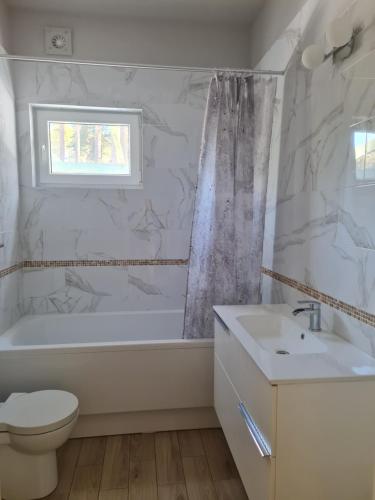 ein Badezimmer mit einer Badewanne, einem WC und einem Waschbecken in der Unterkunft Laimas in Jūrmala