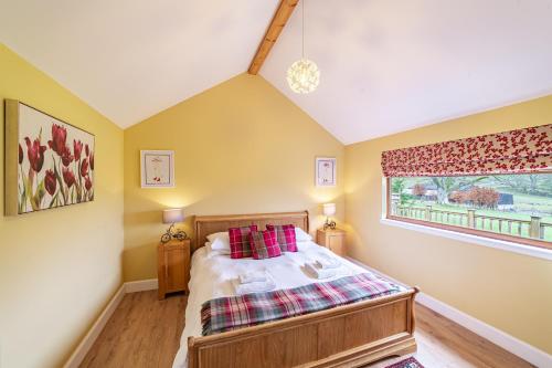 a bedroom with a bed and a window at Pine Marten Lodge with Hot Tub in Cray