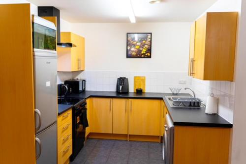 a kitchen with yellow cabinets and black counter tops at Lovely 1-Bed Apartment in Hackney London in London