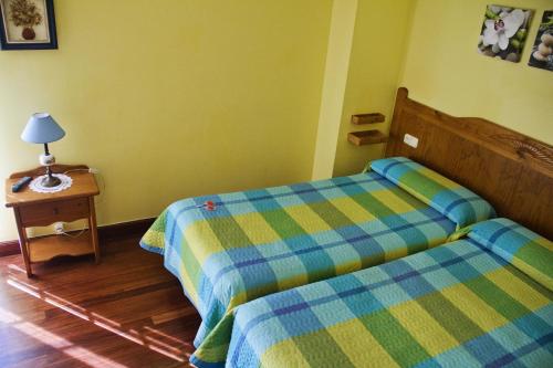 a bedroom with two beds and a table with a lamp at Pension Getariano in Getaria