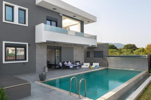 une maison avec une piscine en face d'une maison dans l'établissement Harmony Residences Pool villas, à Ialyssos