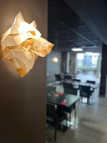 a light fixture hanging on a wall in a restaurant at Hôtel Saphir Lyon in Lyon