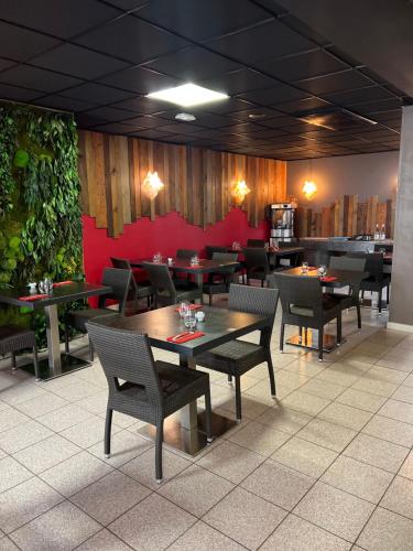 a restaurant with tables and chairs and a red wall at Hôtel Saphir Lyon in Lyon