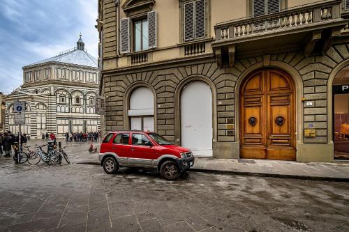 a red car parked in front of a building at Residenza Giotto in Florence