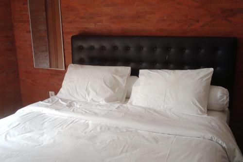 a bed with white sheets and pillows in a bedroom at Villa Adhi Rajasa in Penebel