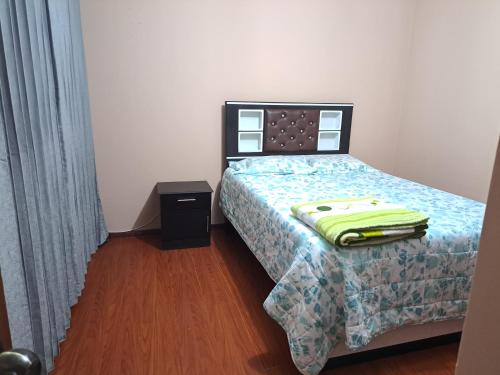 Dormitorio pequeño con cama con manta verde en Departamento amoblado en Arequipa, Cerro Colorado, Urbanización La Merced de Challapampa en Challapampa